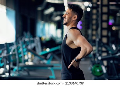 Sport Trauma. Young Arab Male Athlete Suffering Lower Back Pain During Training At Gym, Middle Eastern Sportsman Massaging Sore Zone And Screaming With Ache, Having Injured Lumbar Spine, Copy Space