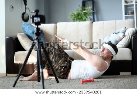 Sport Vlogger Record Press Exercise on Camera. Bearded Man Shooting Video on Digital Camcorder for Spor Vlog. Sportsman Practice Fitness on Floor in Apartment. Sportive Male Training at Home