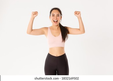 Sport, Wellbeing And Active Lifestyle Concept. Empowered And Strong Asian Female Athlete, Fitness Girl Encourage Herself For Good Workout, Fist Pump And Shouting Upbeat, White Background