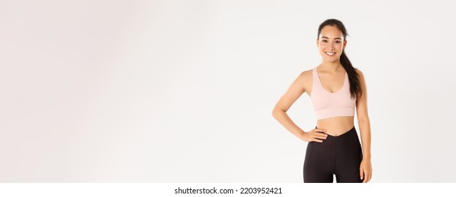 Sport, Wellbeing And Active Lifestyle Concept. Cheerful Smiling Asian Girl Promote You Logo Gym, Special Discount For Membership Or Online Classes App To Workout From Home, White Background