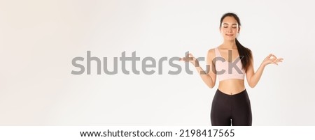 Sport, wellbeing and active lifestyle concept. Smiling calm and relaxed fitness girl, woman in sportswear close eyes and standing in lotus pose, reach nirvana on yoga classes, meditating