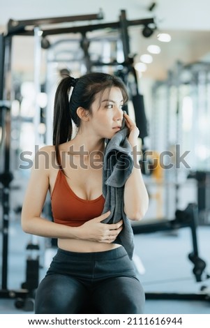 sport woman resting after workout and wipe the sweat by towel. sport and workout concept.