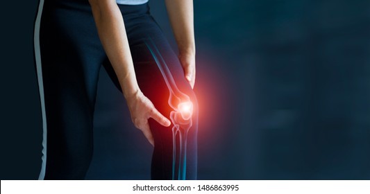 Sport woman suffering from pain in knee. Tendon problems and Joint inflammation on dark background. Healthcare and medical.