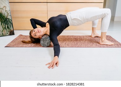 Sport Woman Using Foam Roller For Myofascial Release Exercise For Neck On Mat At Home, After Fitness Exercise, Muscle Strain After High-intensity Workout, Overcome Pain, Rehabilitation Concept.