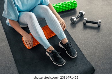 Sport woman using foam roller for muscle and fascia stretching foot. - Powered by Shutterstock