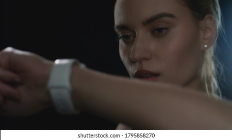 Sport Woman Using Smart Watch On Hand In Black Studio. Portrait Of Fitness Woman Looking Fitness Watch For Counting Calories At Training. Close Uo Of Fit Model Using Modern Sport Accessories