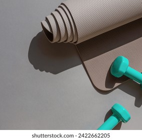 Sport or workout concept flat lay with blue dumbbells, yoga mat on the grey background. Copy space - Powered by Shutterstock