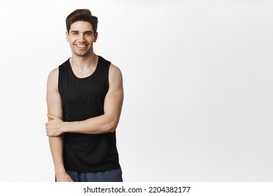 Sport and workout. Handsome smiling man posing in tank top against white studio background. - Powered by Shutterstock