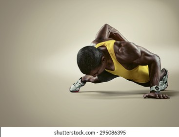 Sport. Young athletic man doing push-ups. Muscular and strong guy exercising. Isolated