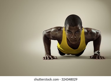 Sport. Young athletic man doing push-ups. Muscular and strong guy exercising. Isolated 