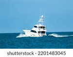 A sportfish motor yacht planes off on the water heading out on a fishing trip