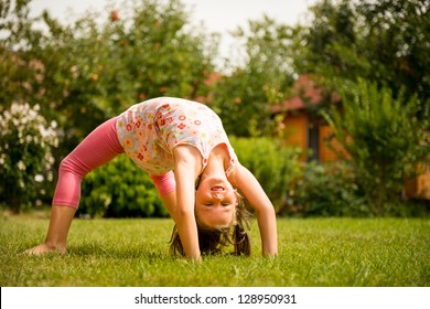 Sporting on grass - smiling little child making bridge outdoor in backyard - Powered by Shutterstock