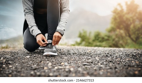 sporting the right footwear is an important factor. Closeup shot of a sporty woman tying her shoelaces while exercising outdoors.