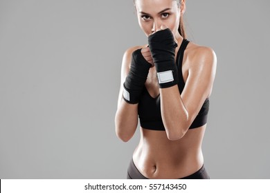 Sporting Woman In Boxing Bandages In Studio Looking At Camera. Isolated Gray Background