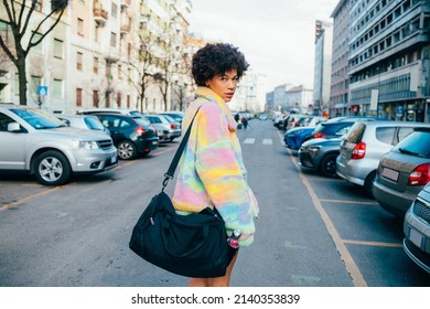 Sportive black young woman walking outdoor holding duffel bag going gym