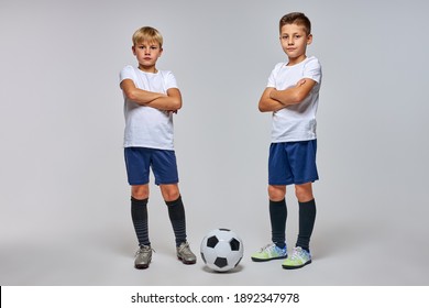 sportive boys go in for soccer sport game, caucasian children in uniform posing at camera with crossed arms, confidently looking - Powered by Shutterstock