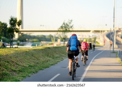 Sportive Couple Cycling By Ada Bridge Over The Sava River In Belgrade, Serbia, On Hot Summer Day. Nice Sport For Active People. Healthy Lifestyle. Tourism And Travel In Europe.