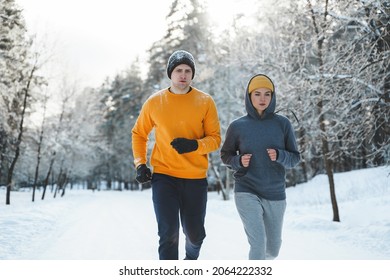 Sportive couple during winter jogging in snowy city park