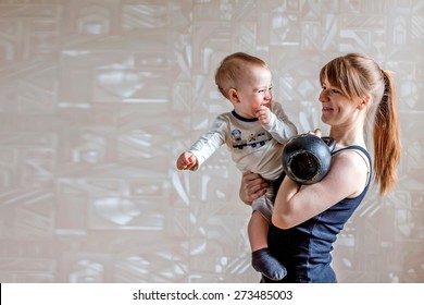 Sportive happy mother and son and kettlebell in hands. Motherhood is not a cause to let oneself go