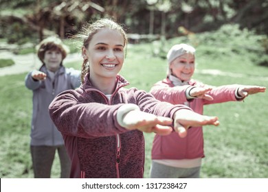 Sportive lady. Beautiful sportive lady smiling while looking straight during exercise on hand - Shutterstock ID 1317238427