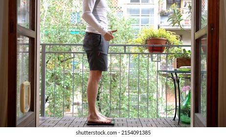 Sportive Man 40 Years Old Measure Weight At Home In The Balcony After Sport Activities  - Physical Training With The Arrival Of Spring They Get Ready For Summer