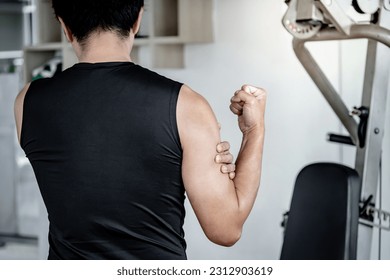 Sportive man feeling upper arm muscle pain after doing weight training exercise in fitness gym. Male athlete suffering from acute bicep muscular inflammation symptom. Sport injury concept - Powered by Shutterstock