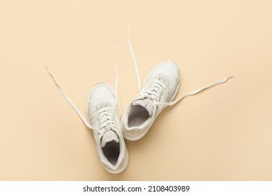 Sportive Shoes With Untied Laces On Color Background