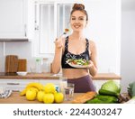 Sportive woman eating vegetable salad at home
