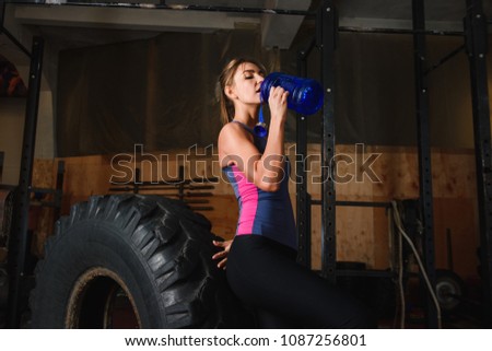 Sportive woman in gym drink water