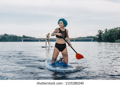 Sportive Women Standup Paddleboarding On River