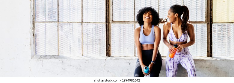 Sportive women talking in a gym while drinking water - Powered by Shutterstock