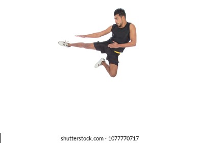 Sportive Young Man Wearing A Sportswear, Playing Kickboxing, Jumping In The Air And Kicking Someone With His Leg, Isolated On White Background.