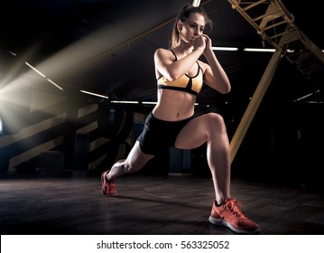 Sportive young woman in a gym training. Working out in a fitness gym. - Shutterstock ID 563325052