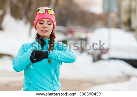 Sports and activities in winter time. Slim fit fitness woman outdoor. Athlete girl training wearing warm sporty clothes outside in cold snow weather.