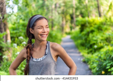 Sports Asian Girl Smiling Happy With Her Run Exercise. Runner Woman Satisfied Feeling Good After Jogging In City Park On Forest Path. Sportswoman Wearing Fitness Grey Tank Top Activewear And Headband