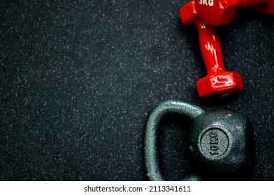 Sports Background, Dumbbells And Kettlebell On The Floor In The Fitness Room.