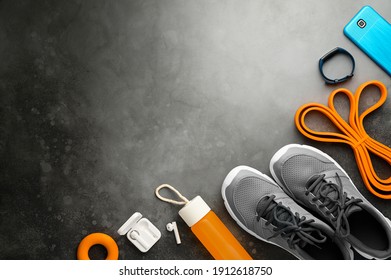 Sports Background. Equipment For Training And Outfit On Grey Stone Background. Fitness, Workout At Home. Flat Lay, Top View, Copy Space. Dark Moody Style