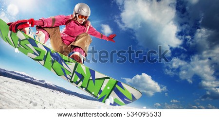 Sports background. Snowboarder jumping through air with deep blue sky in background.