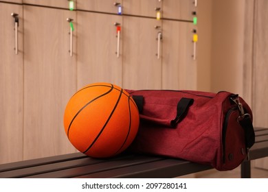 Sports Bag And Basketball Ball On Wooden Bench In Locker Room