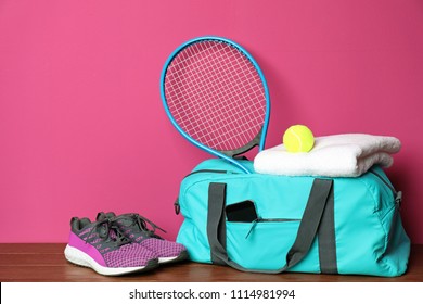 Sports bag and equipment for tennis on wooden floor against color background - Powered by Shutterstock