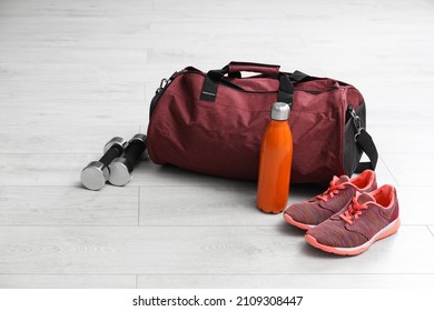 Sports bag and gym stuff on white floor