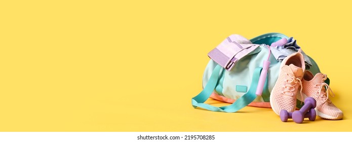 Sports bag, shoes and dumbbells on yellow background with space for text - Powered by Shutterstock