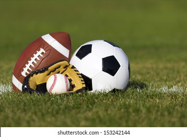 Sports balls on the field with yard line. Soccer ball, American football and Baseball in yellow glove on green grass. Outdoors   - Powered by Shutterstock