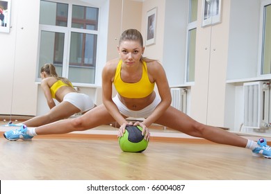 Sports blonde girl do the splits in gym - Powered by Shutterstock