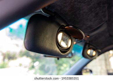 Sports Car Cockpit Shows Drivers And Passengers Sun Visors Flipped Open With Vanity Lights And Mirror Visible.