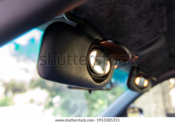Sports car cockpit
shows drivers and passengers sun visors flipped open with vanity
lights and mirror
visible.