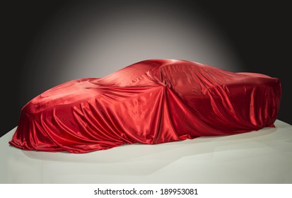 Sports Car Is Covered With A Red Cloth