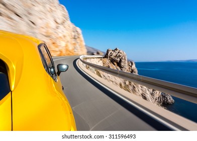 Sports Car Driving Fast On A Winding Road By The Sea