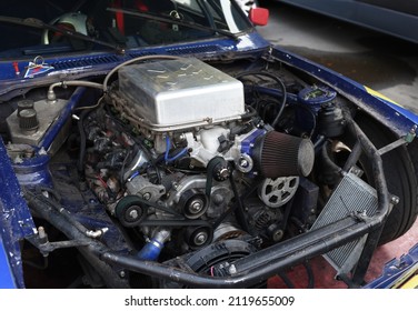 Sports Car Engine With Turbine. An Open Race Car Hood On A Pit Stop While Racing On A Race Track. Motor With Turbocharger. Boos And Tunning.