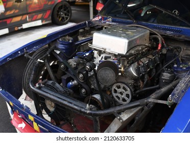 Sports Car Engine With Turbine. An Open Race Car Hood On A Pit Stop While Racing On A Race Track. Motor With Turbocharger. Boos And Tunning.